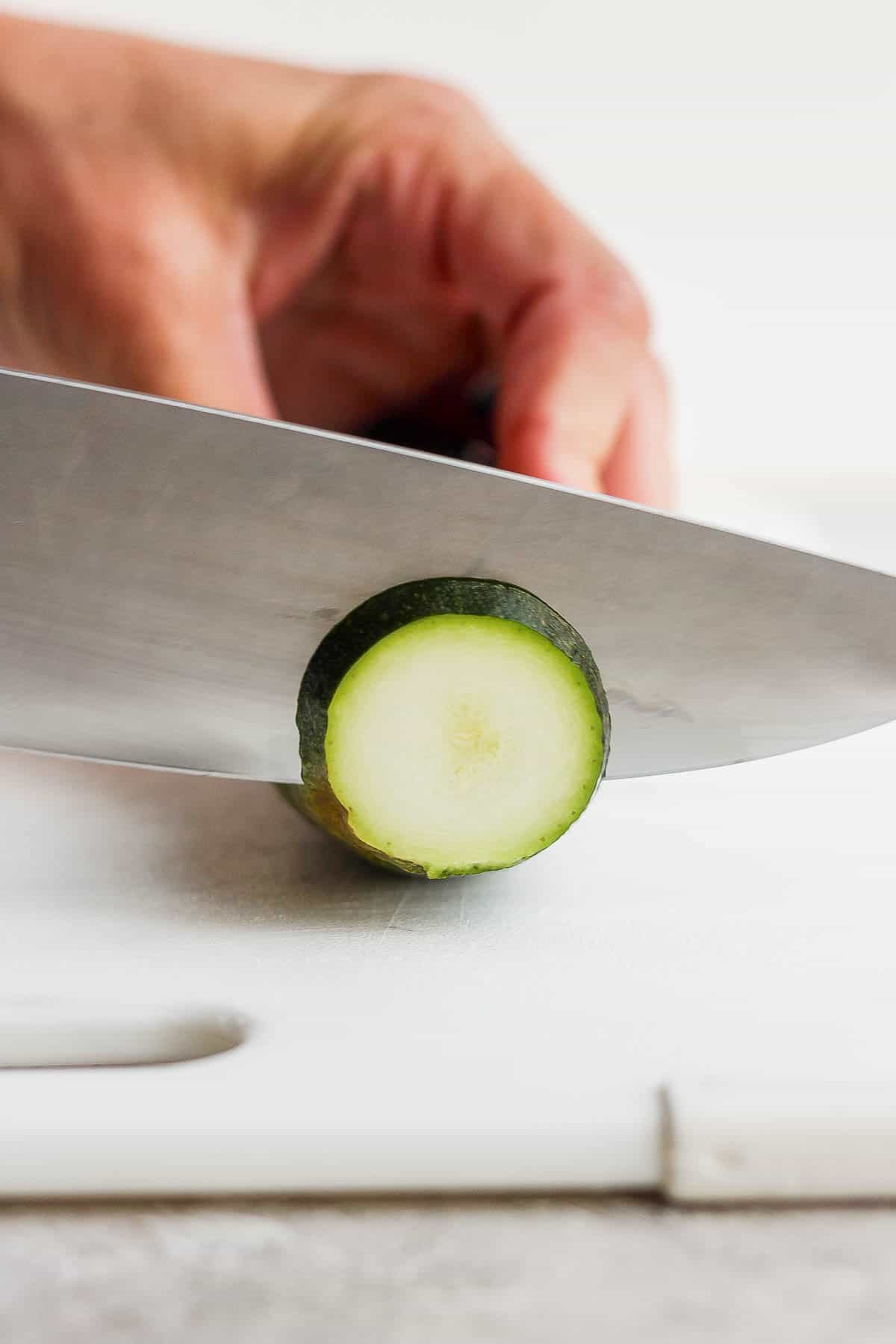 Zucchini being cut into slices.