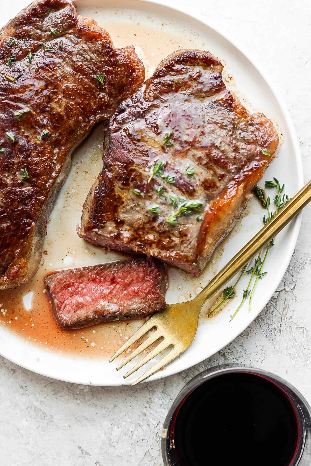 A piece of steak cut on the plate with a fork on the side.