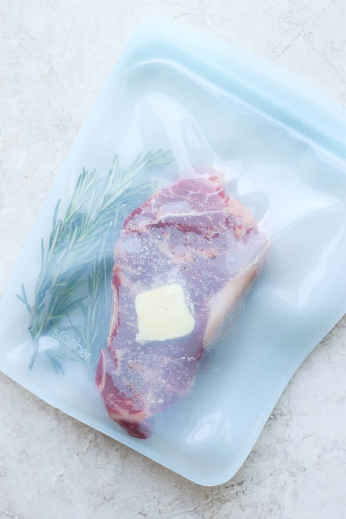 Steak in a stasher bag with fresh herbs and butter.