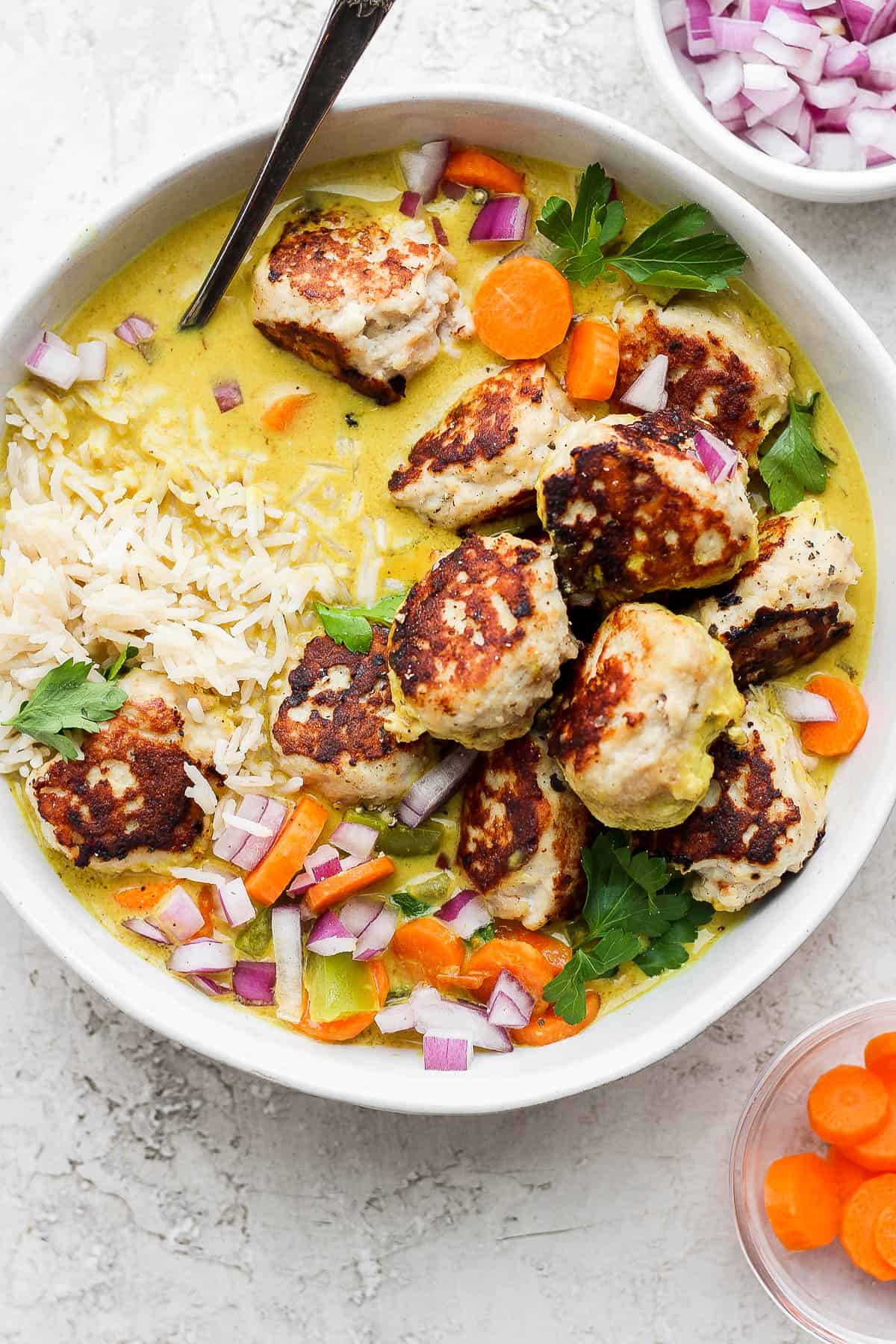 Meatball curry in a bowl with rice.