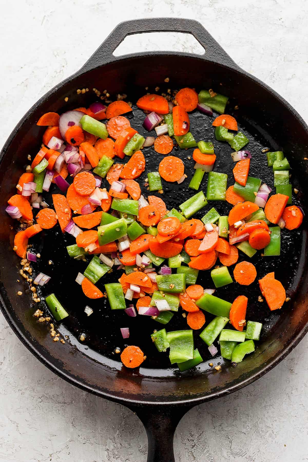 Veggies for meatball curry in a skillet.