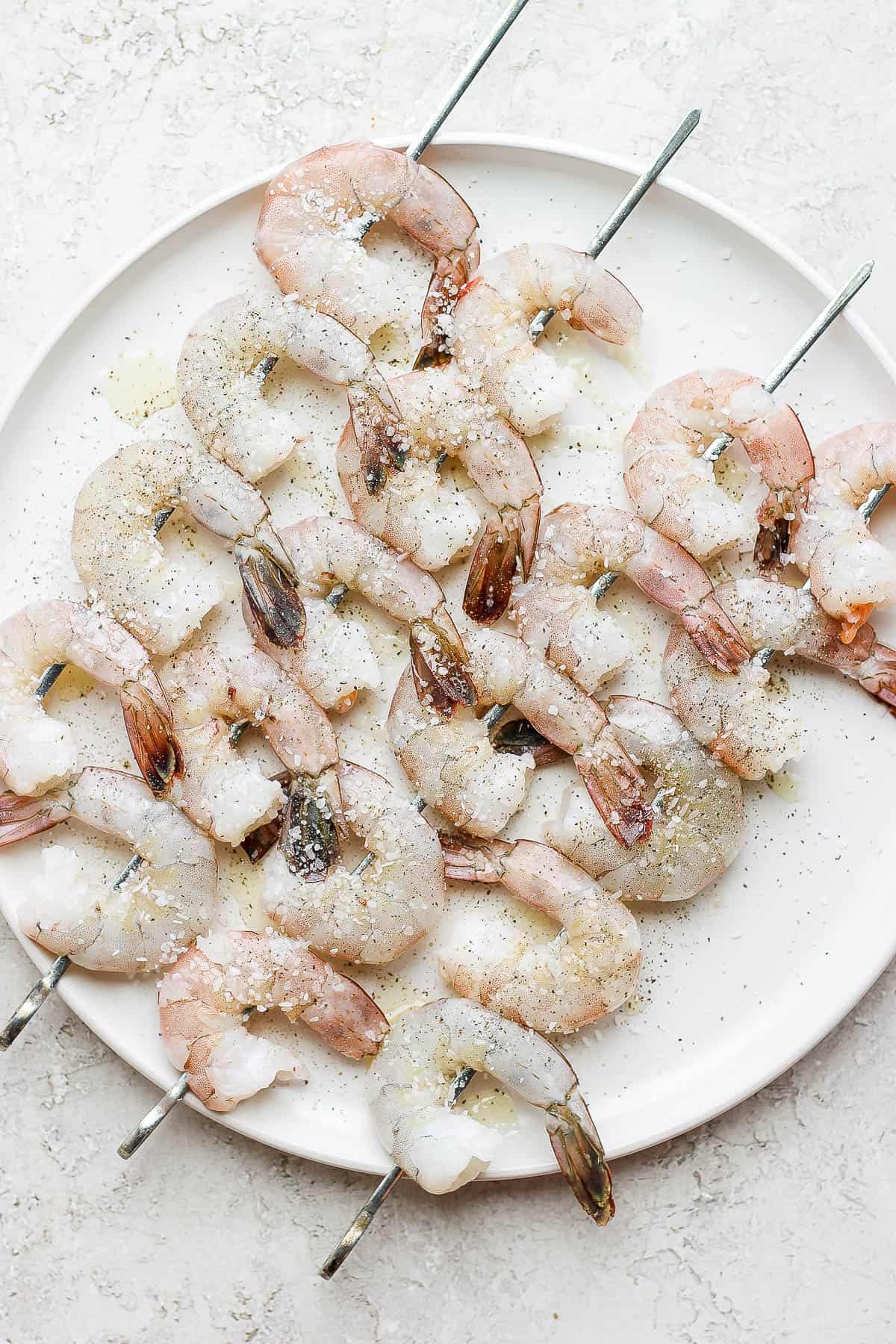 Shrimp on skewers that were brushed with olive oil and sprinkled with salt and pepper.