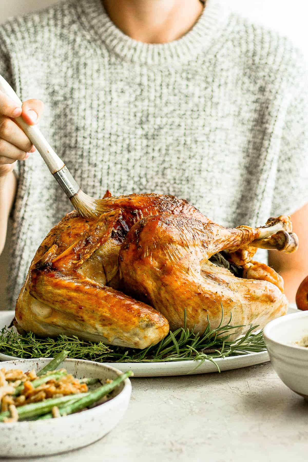 A cooked turkey being basted.