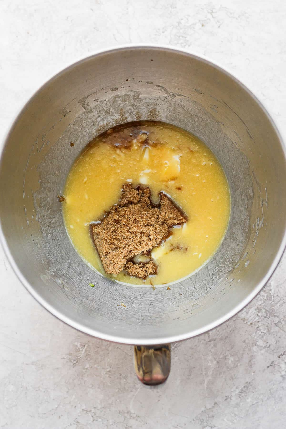 Eggs, melted butter, brown sugar, and vanilla extract in a stand mixing bowl.