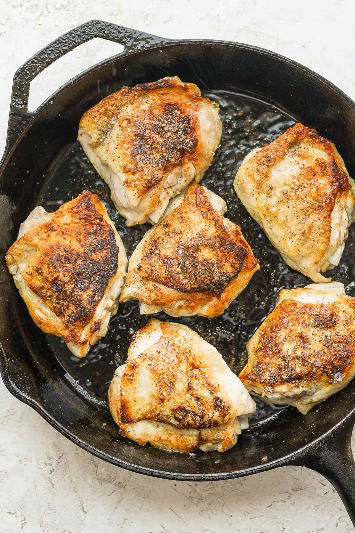 Seared chicken thighs in the cast iron skillet.