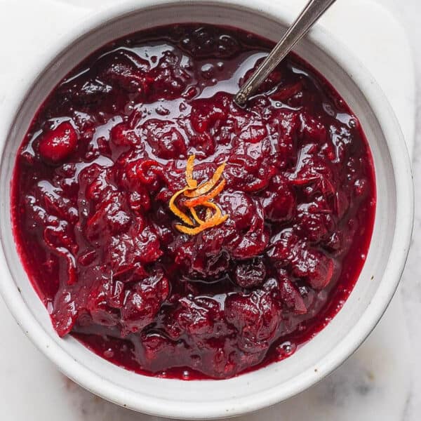 Bowl of cranberry orange sauce with spoon sticking out.