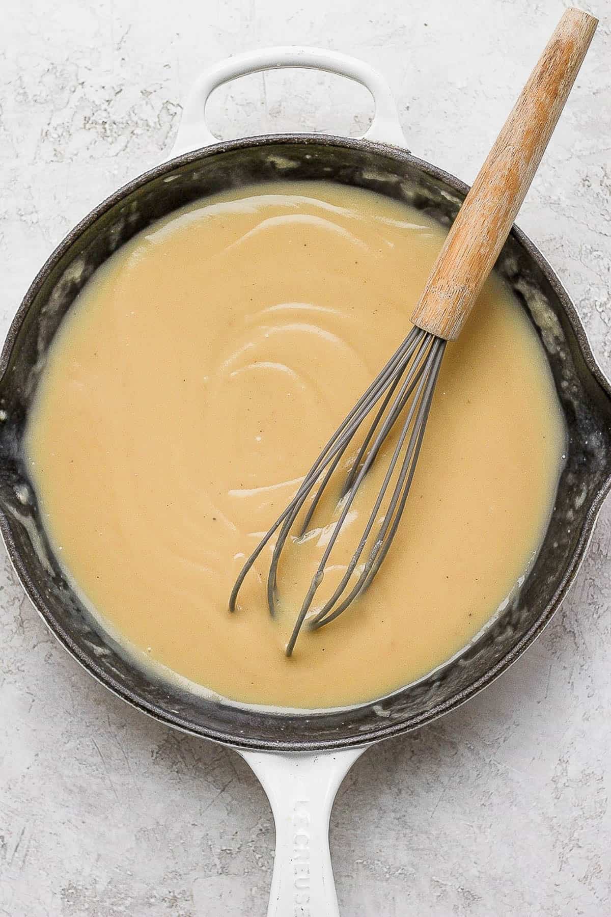 Turkey giblet gravy in the skillet with a whisk.