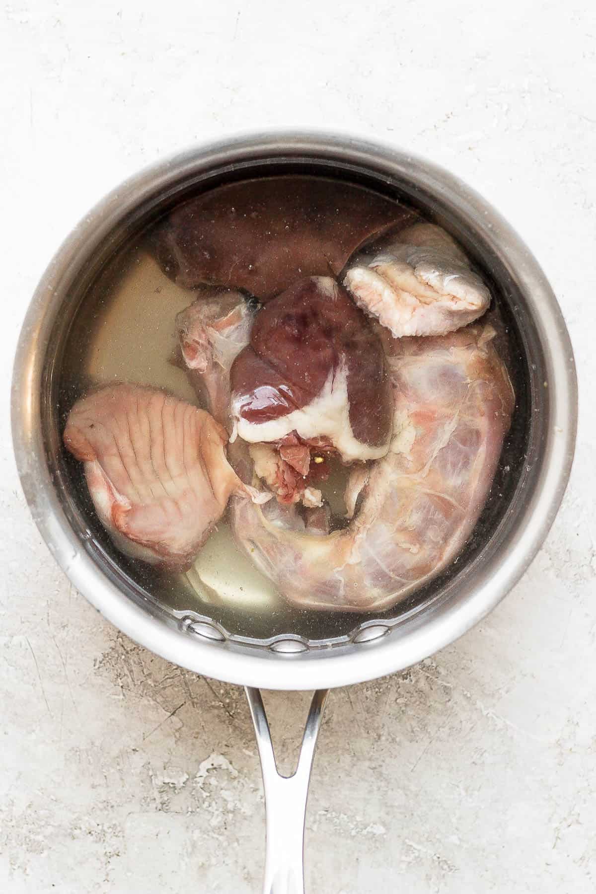 Turkey giblets in a large saucepan with water.