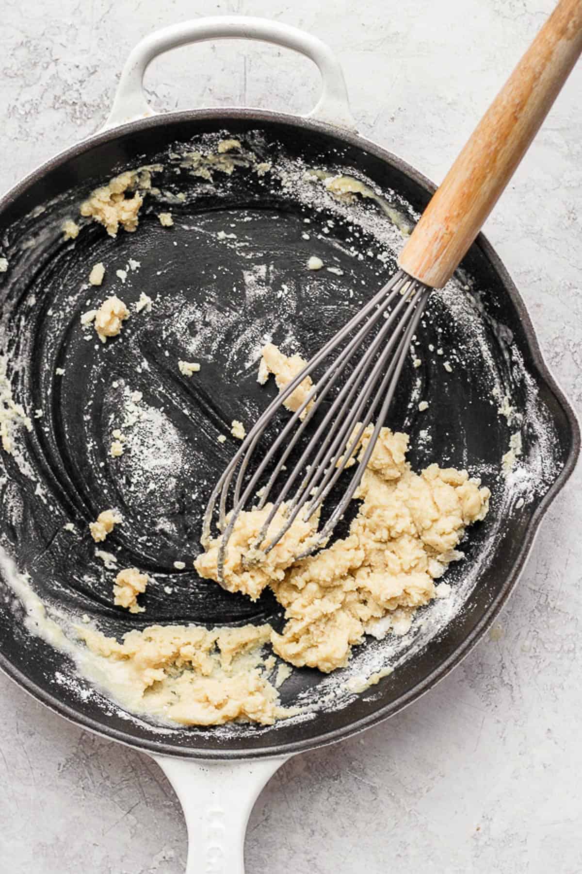 A whisk turning the butter and flour into a roux.