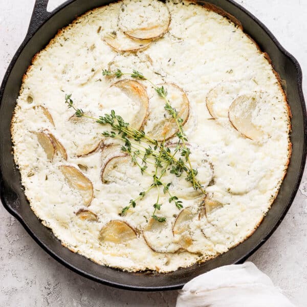 A cast iron skillet filled with goat cheese potatoes au gratin.