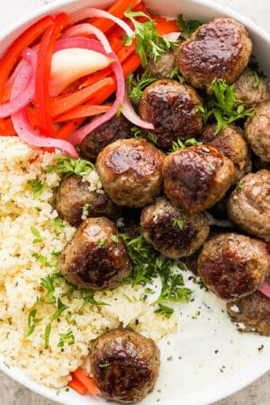 A bowl of Greek meatballs, quinoa, whipped feta and pickled veggies.