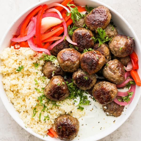 A bowl of Greek meatballs, quinoa, whipped feta and pickled veggies.