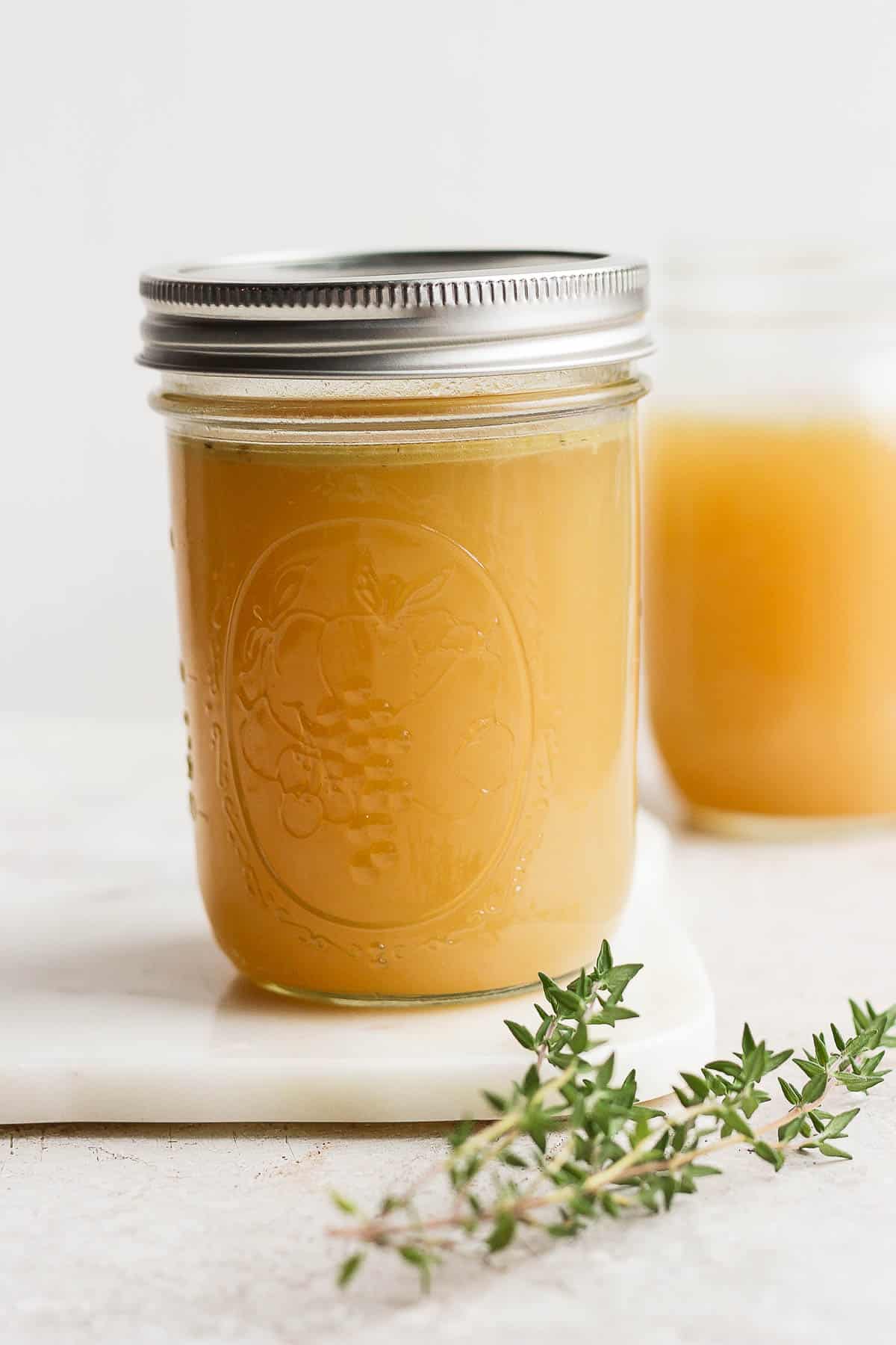 Two mason jars filled with turkey stock. 