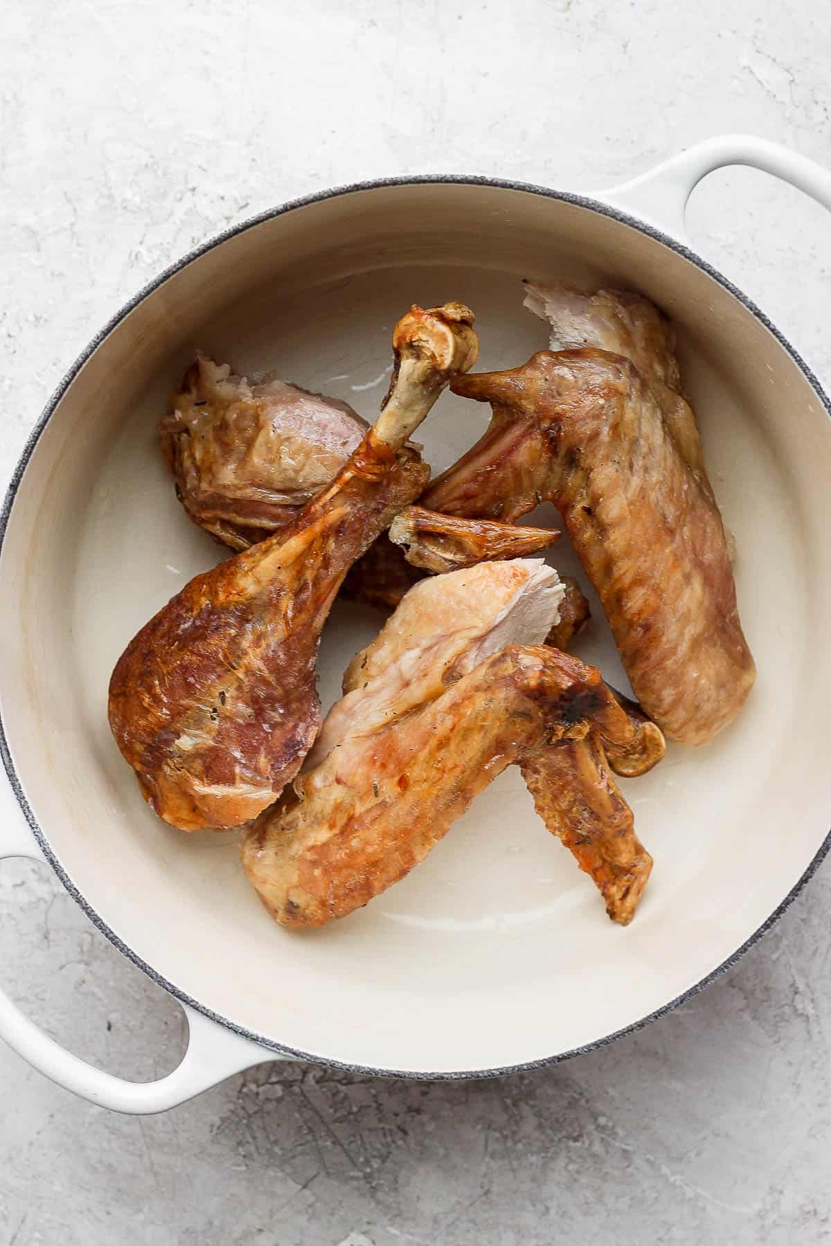 Turkey bones with some flesh and skin in a dutch oven.