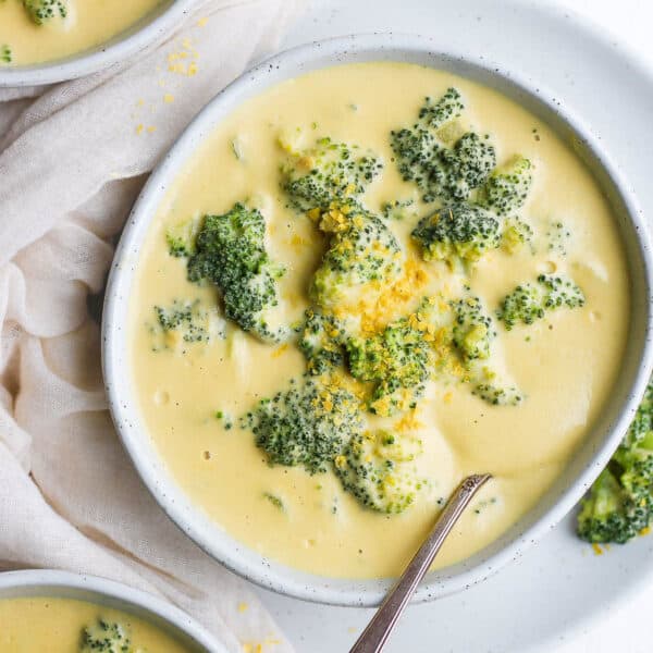 A bowl of dairy-free broccoli cheese soup with a spoon sticking out.