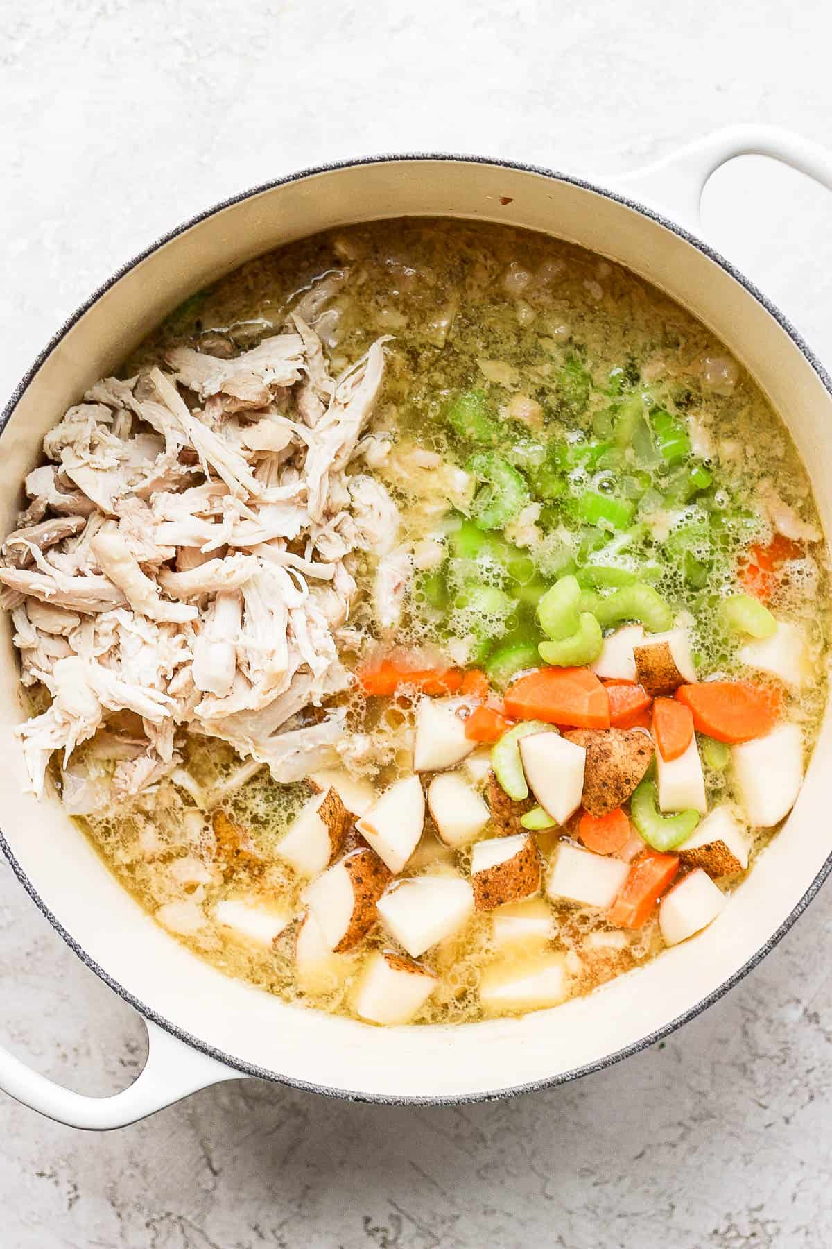 Vegetables and shredded chicken added to the pot.