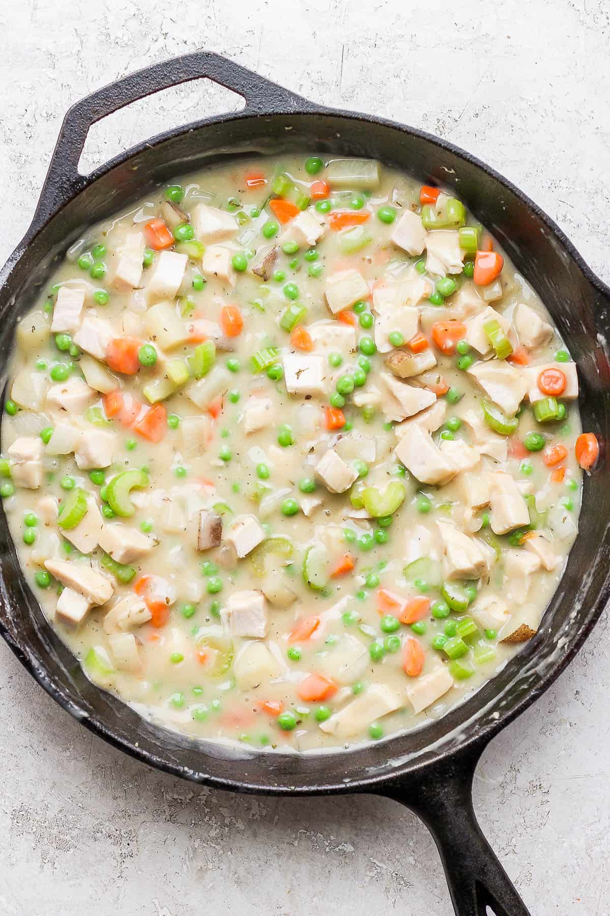 The turkey pot pie filling in a cast iron skillet.