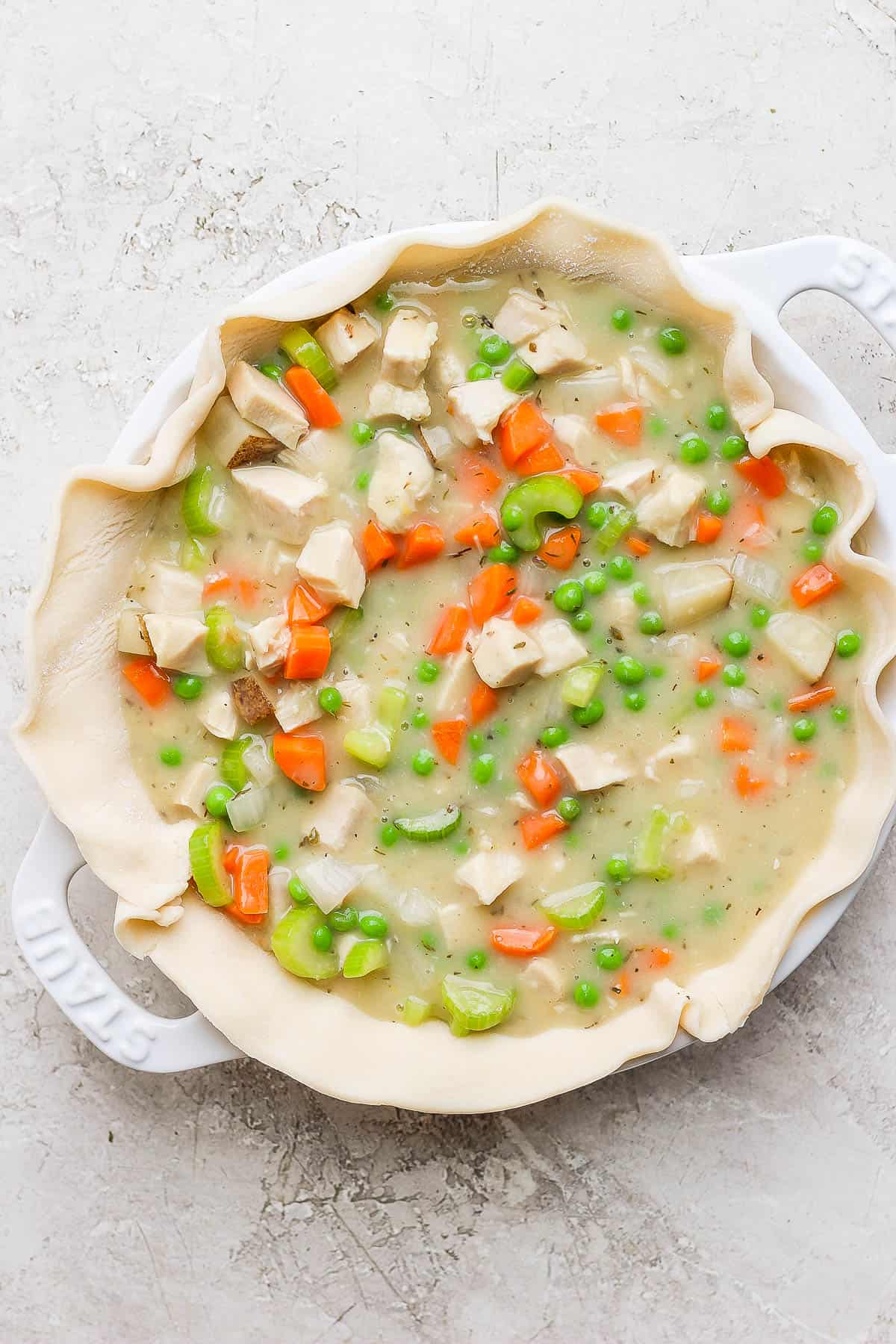 One pie crust sheet placed in a prepared baking dish with the pot pie filling added.