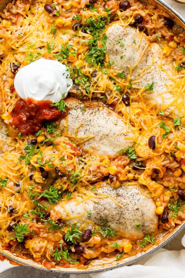 Baked salsa chicken in a braiser fresh cilaantro, sour cream and salsa.