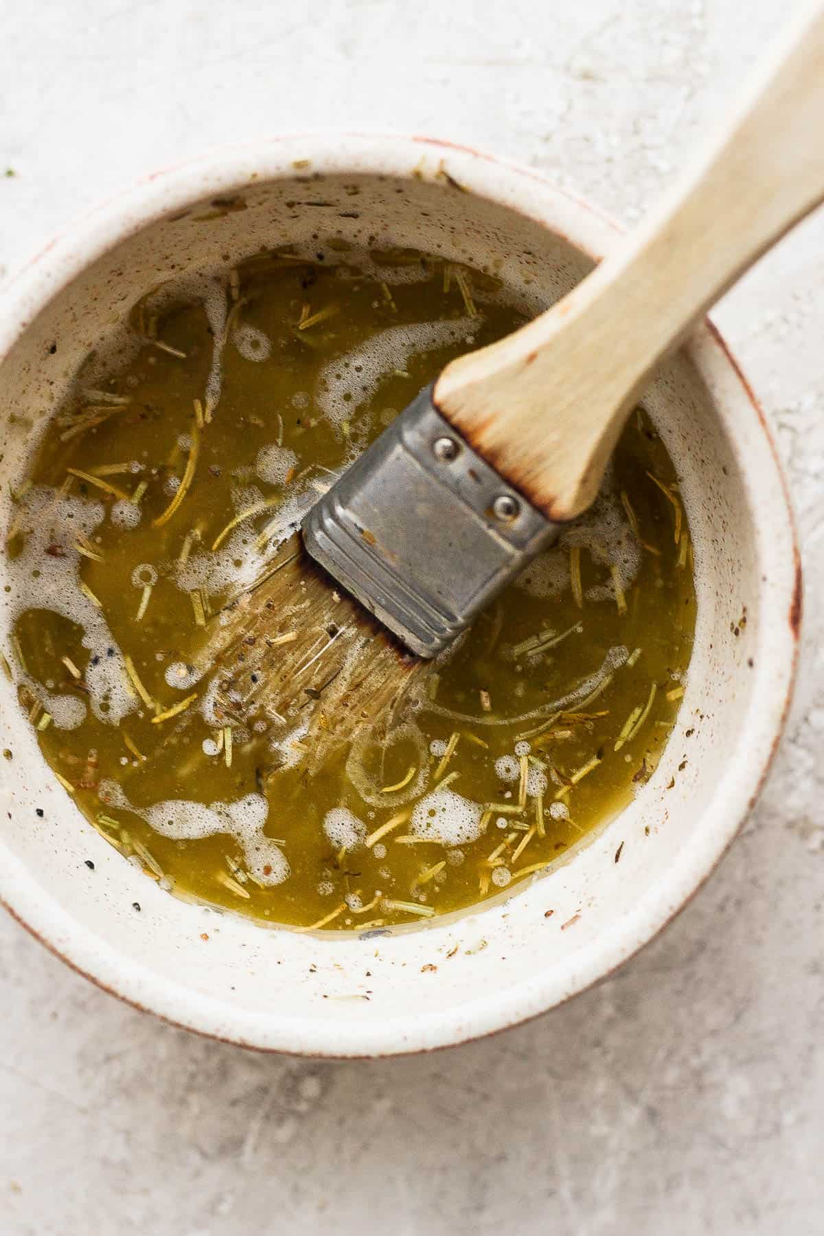 Turkey baste in a bowl with a basting brush.