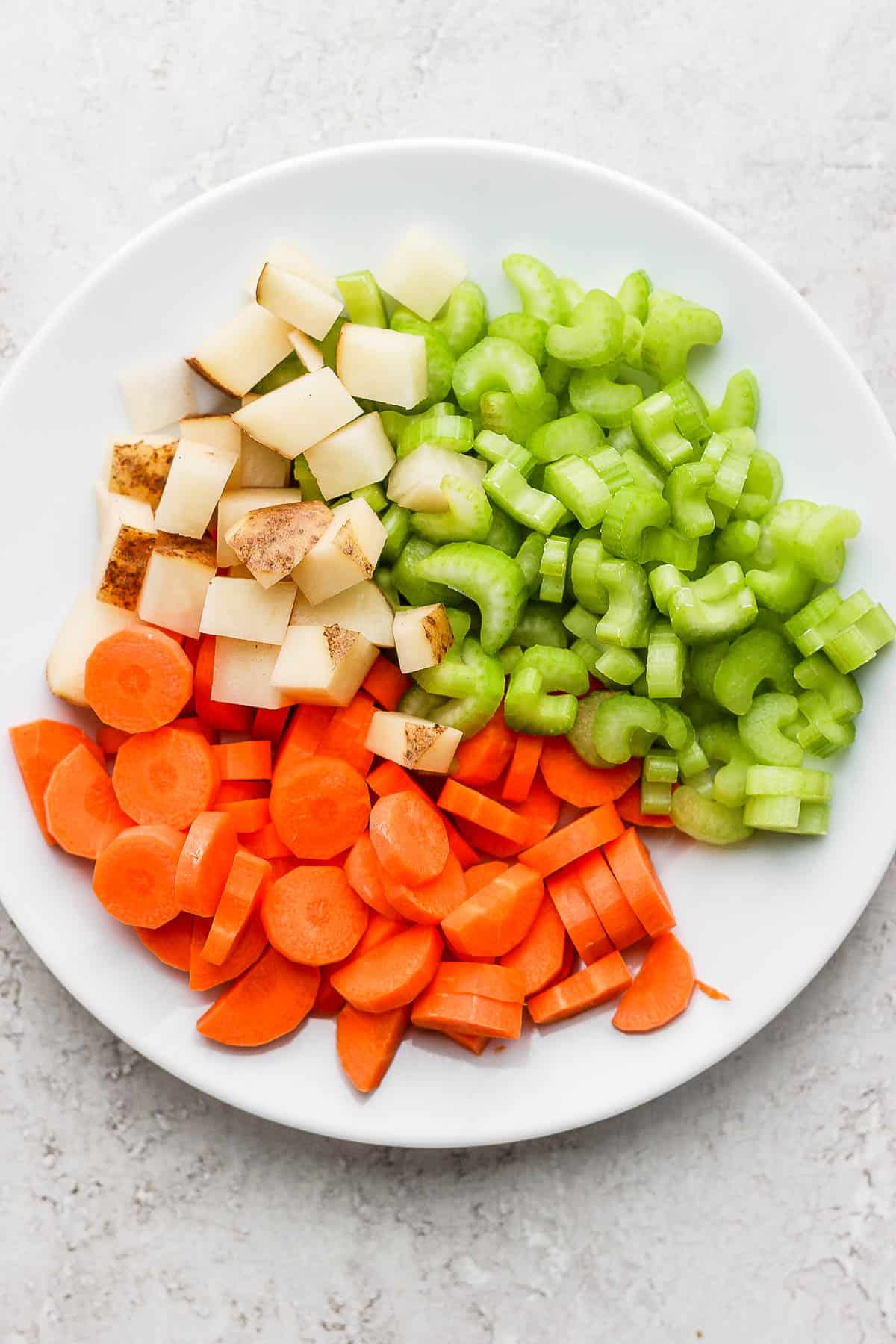 Cut-up vegetables on a white plate.