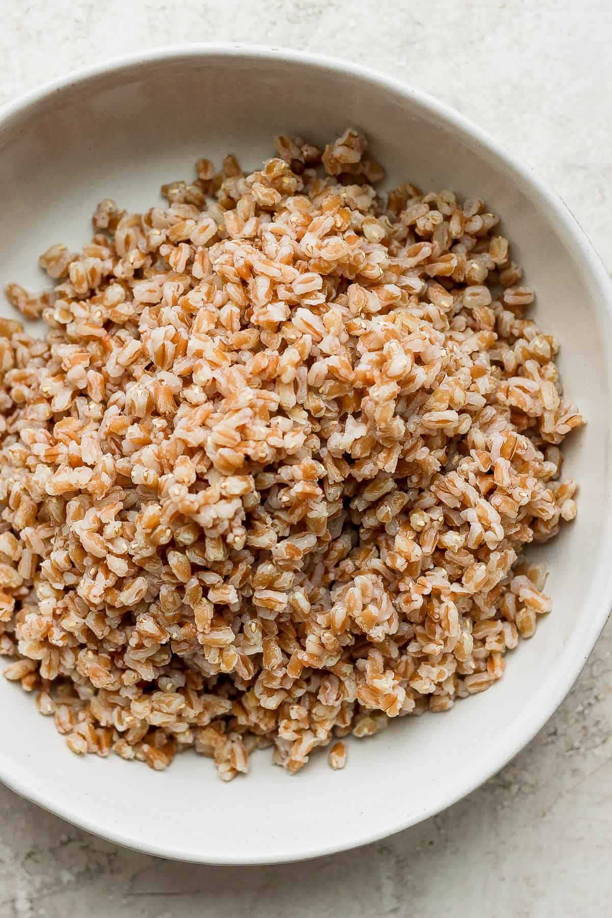 Cooked farro in a white bowl.