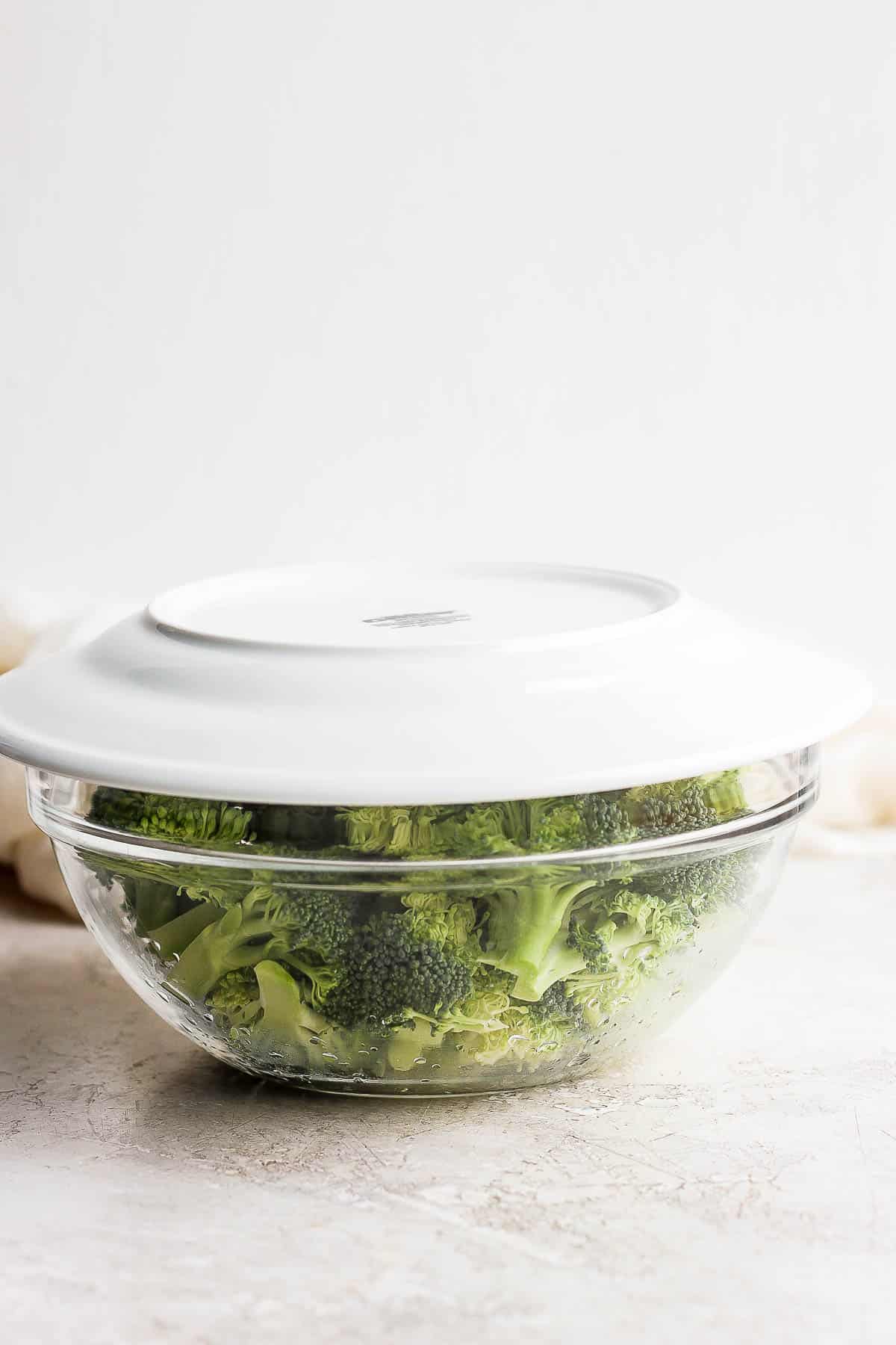 A plate on top of broccoli in a bowl.