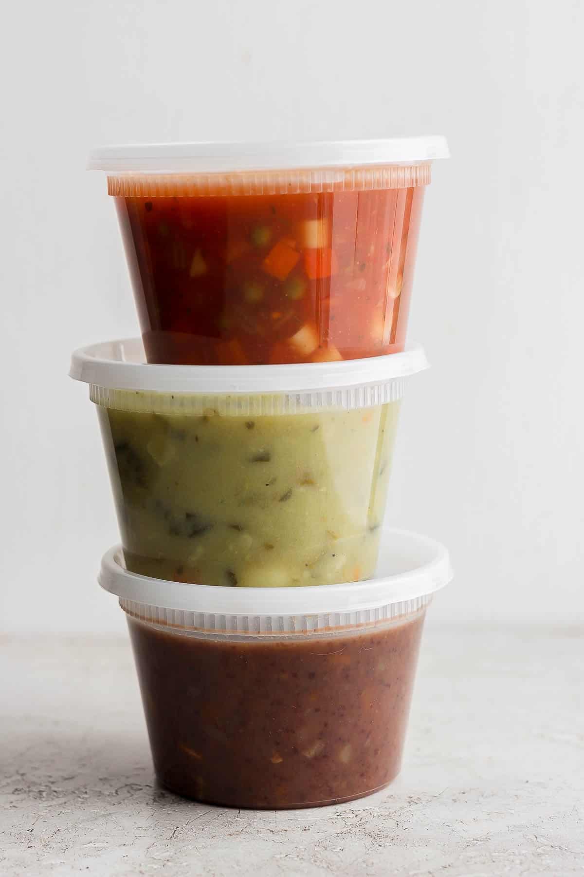 Three containers of soup stacked on top of each other.