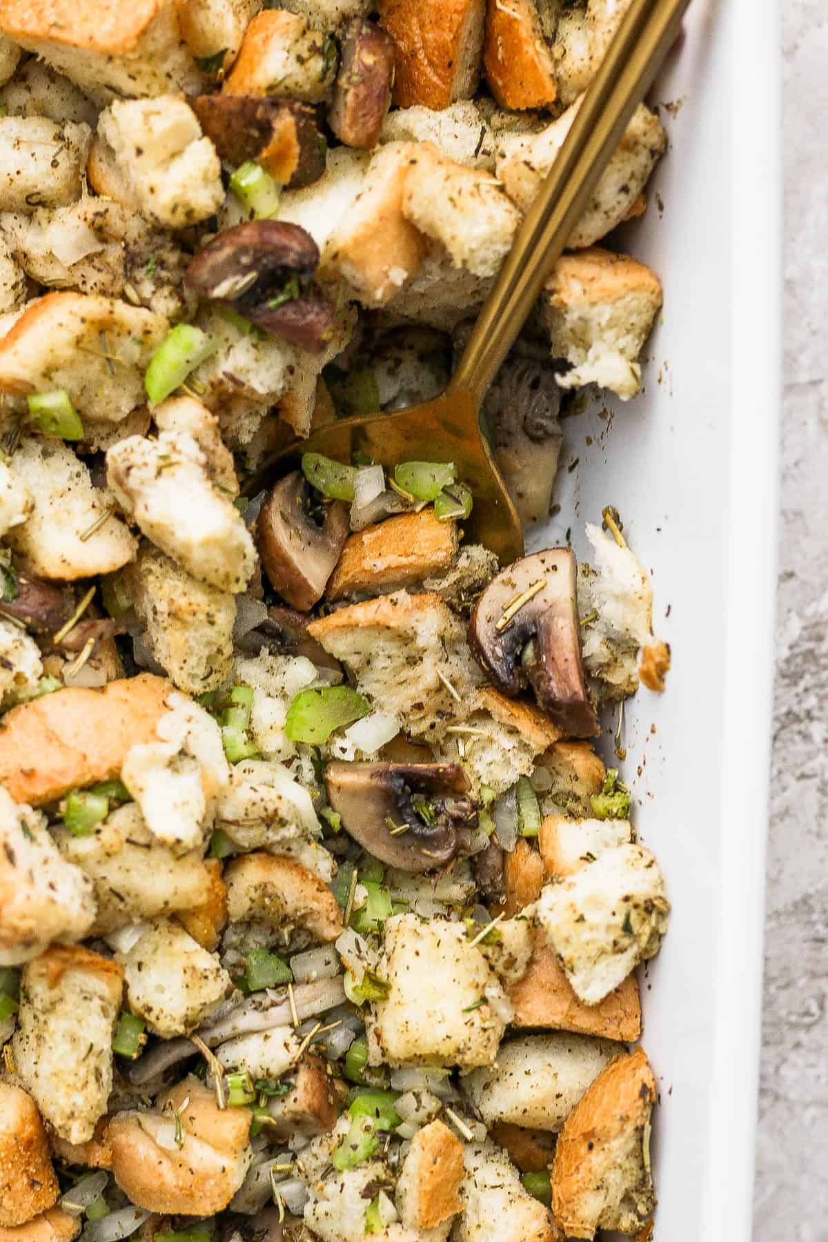 A spoon in the baking dish with the stuffing.