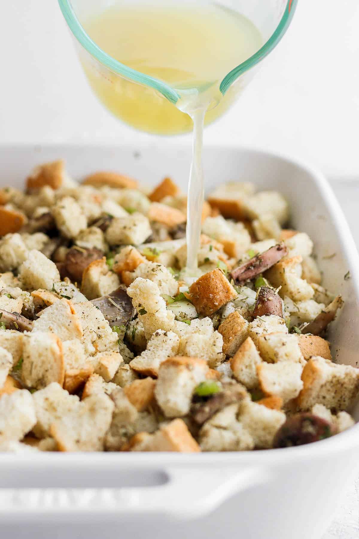 Broth being poured on top of the stuffing mixture.