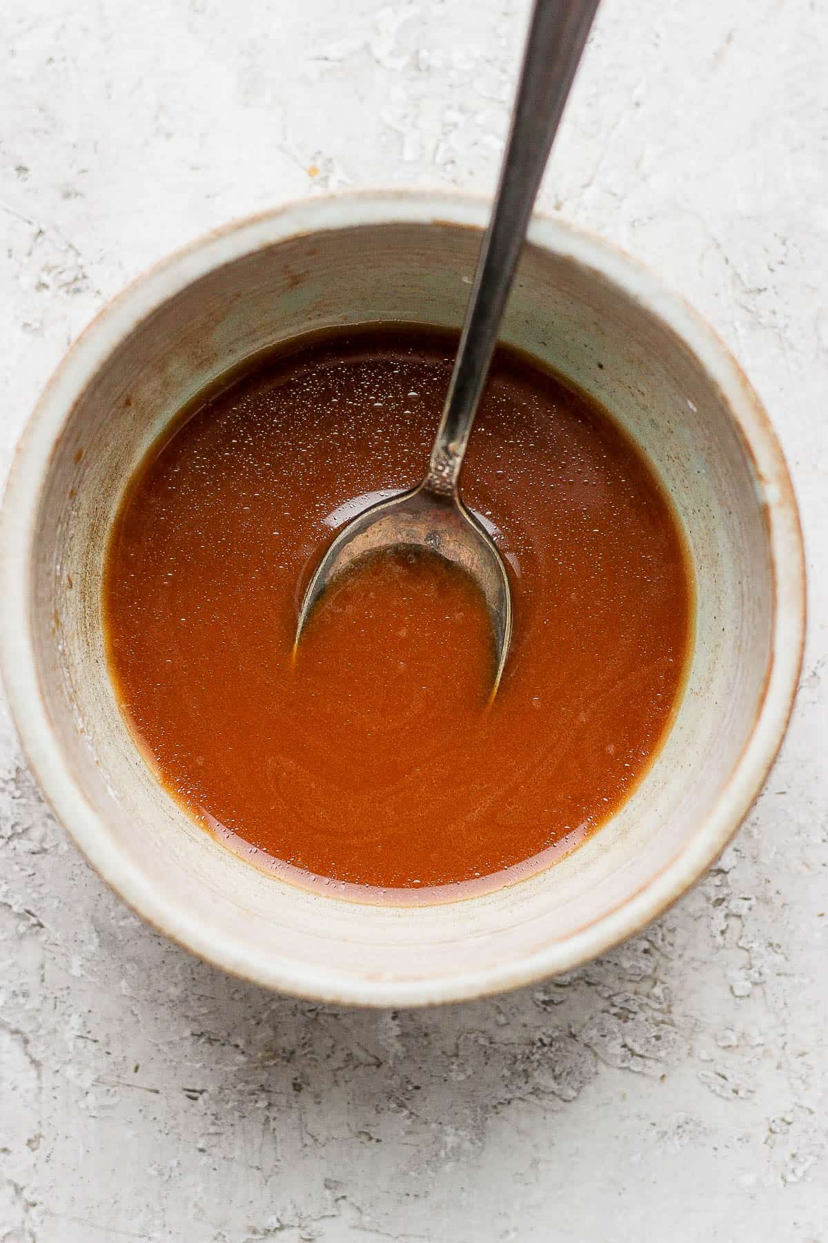 Kung Pao sauce in a small bowl with a spoon.