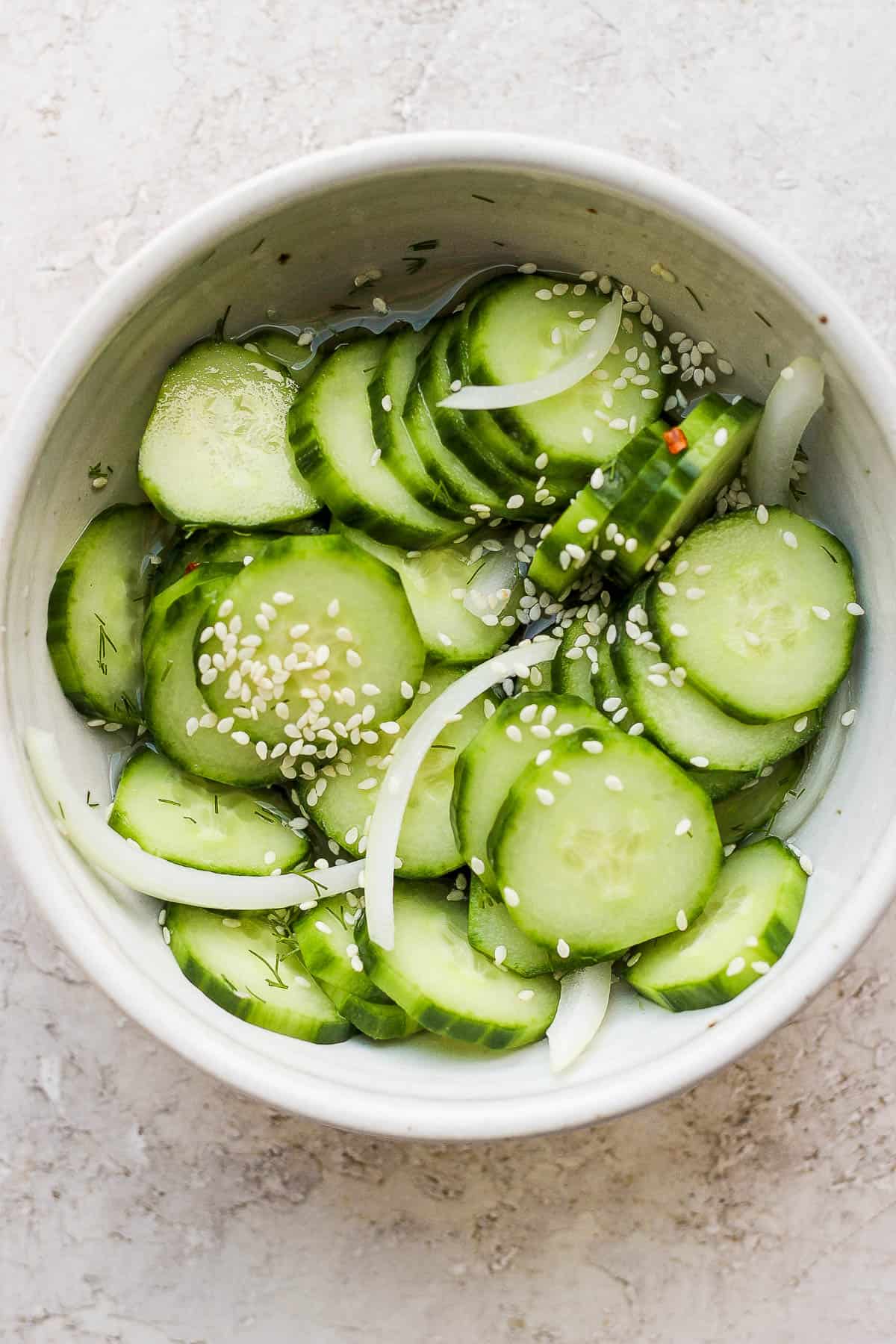 All of the marinated cucumber ingredients mixed together in a bowl.