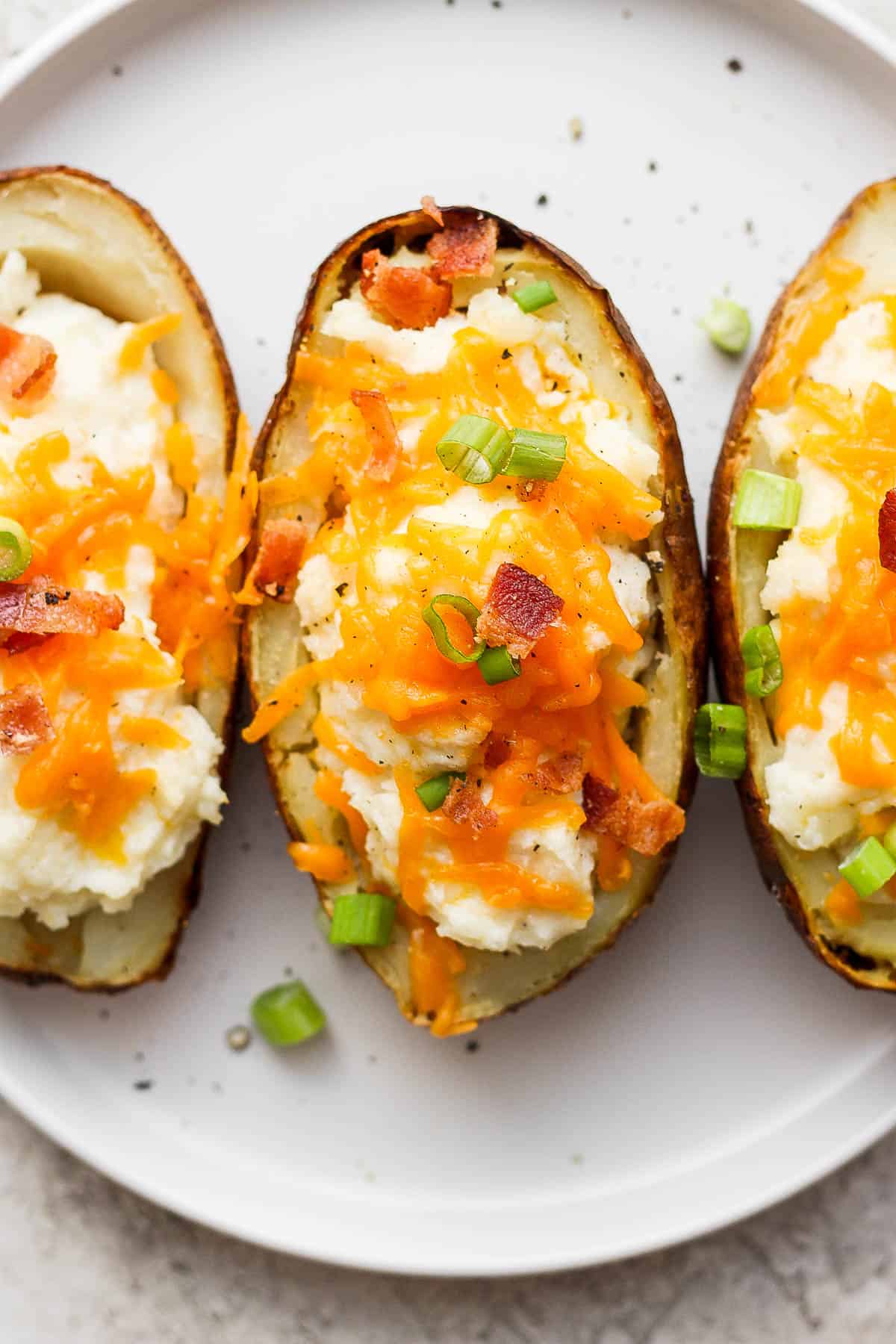 Twice baked potatoes on a white plate.