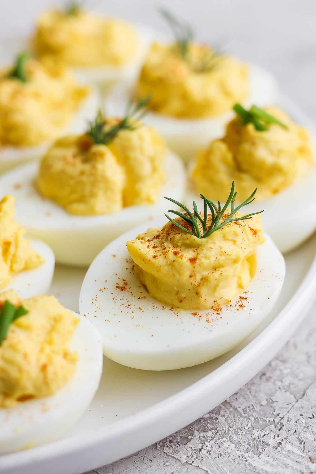 Close up image of deviled eggs on a white plate.