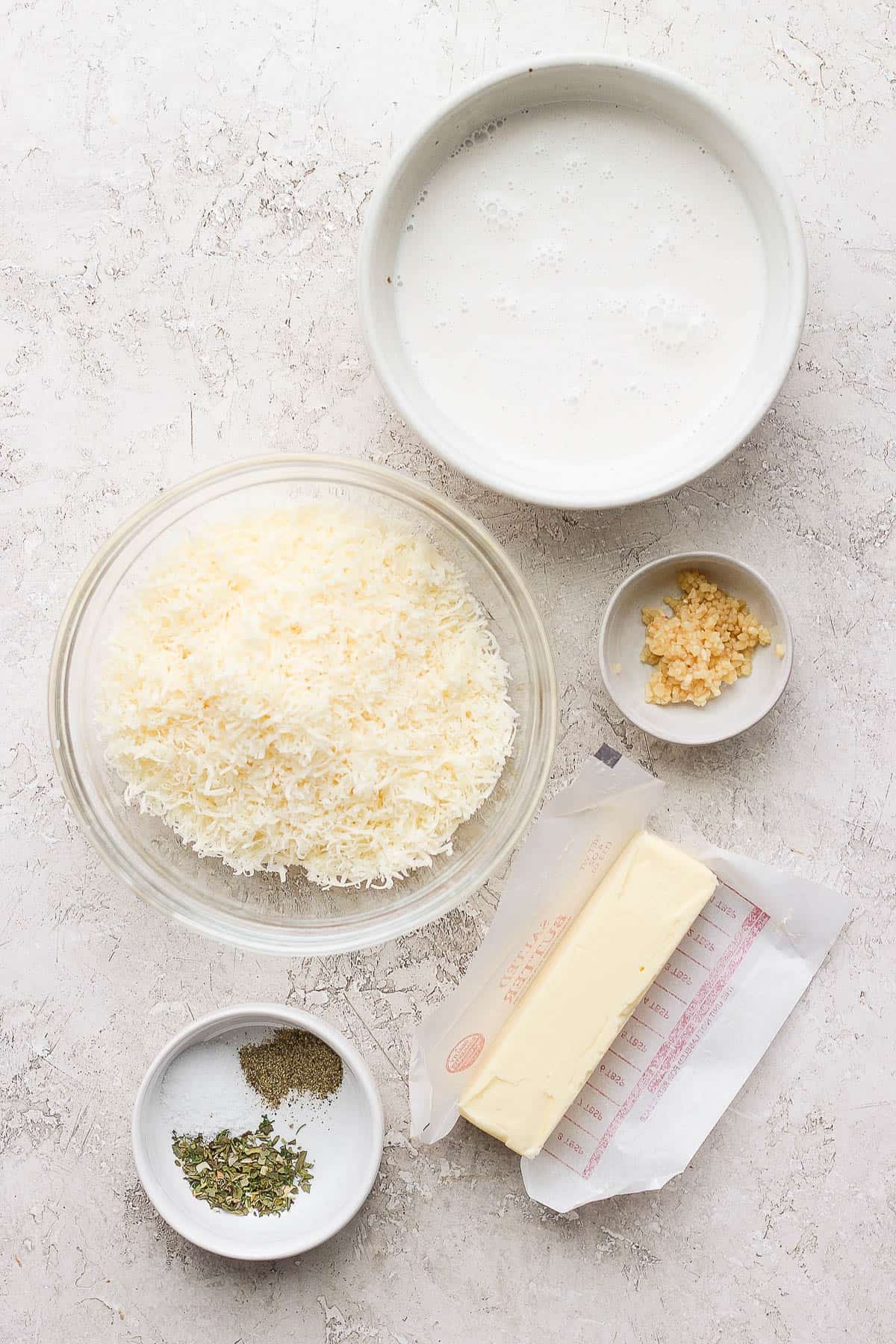 Ingredients for alfredo sauce in a separate bowls.