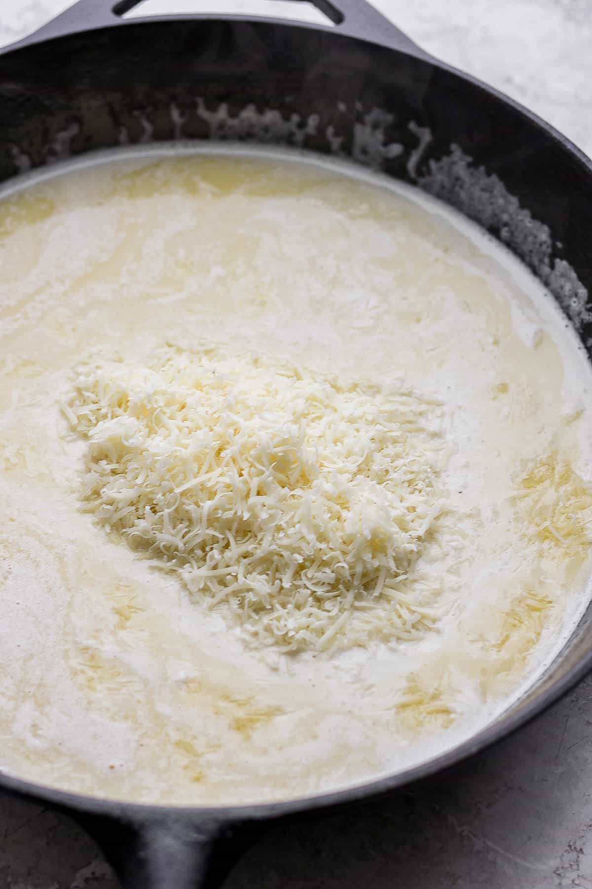 Freshly grated parmesan cheese added to the pan.