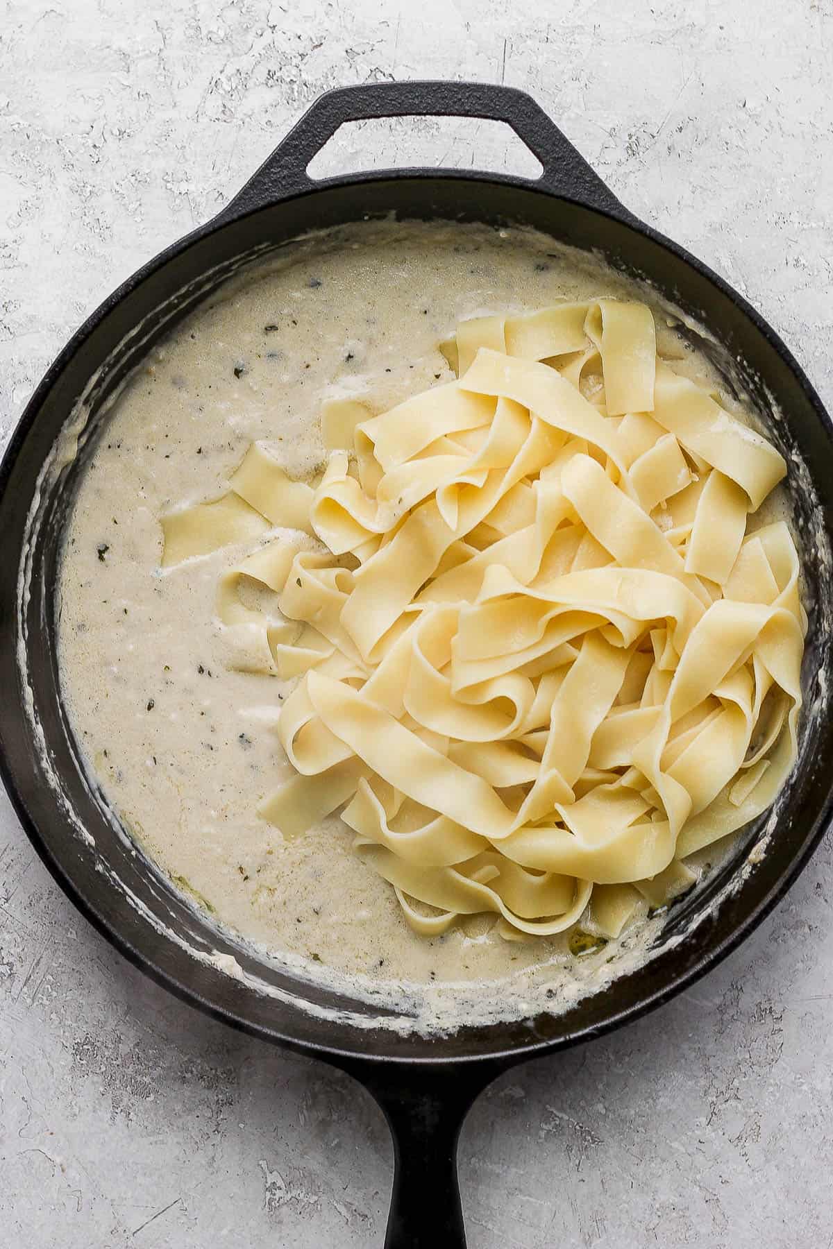 Al dente noodles added to the pan of sauce.