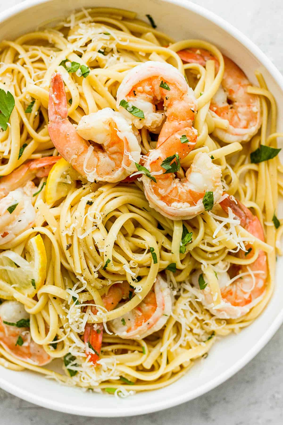 Shrimp scampi pasta in a white bowl.