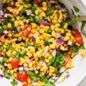 Bowl of fresh corn salsa with tomatoes and cilantro.