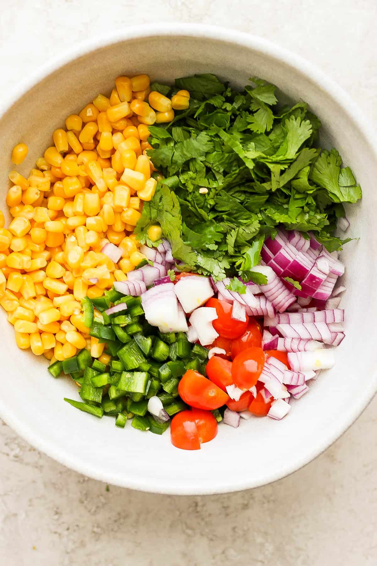 All of the salsa ingredients in a bowl. 