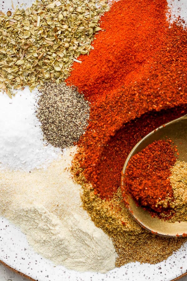 Plate of fajita seasoning with a golden spoon sticking out.