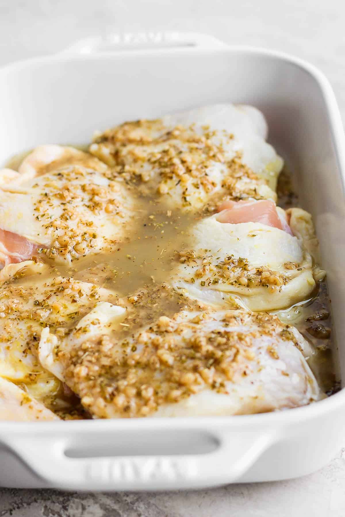 Greek marinade poured over the chicken thighs in the casserole dish. 