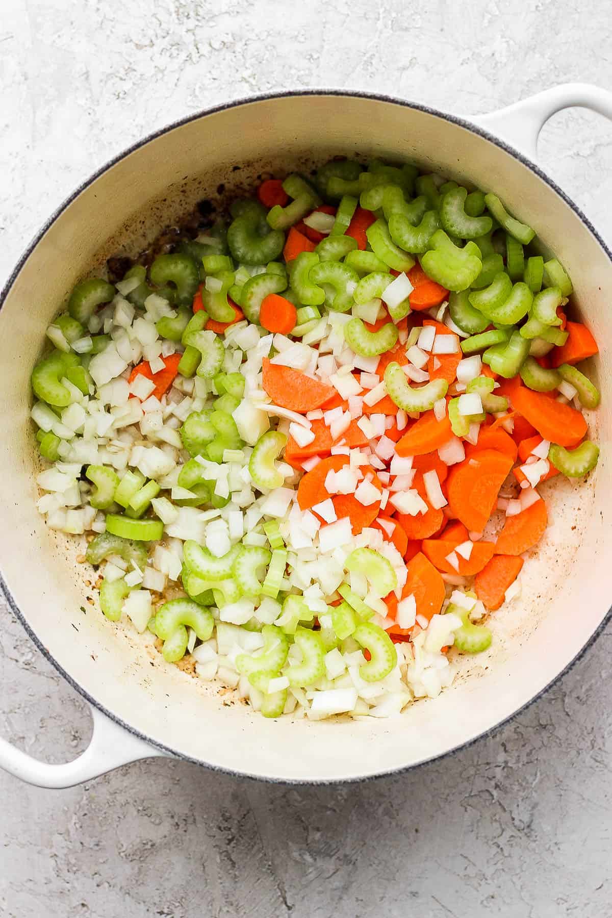 A large pot with garlic, onion, carrots, and celery added.