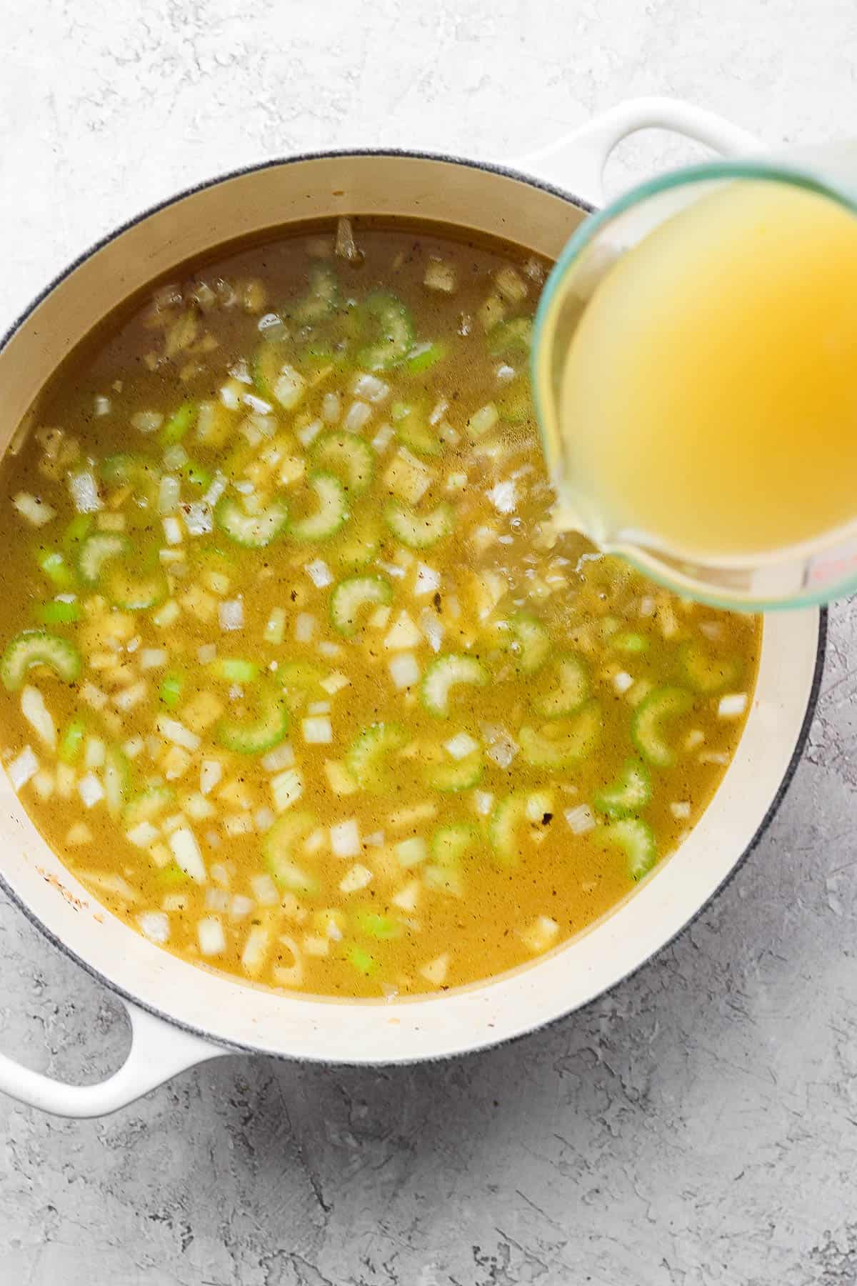 Chicken broth being poured into the pot.