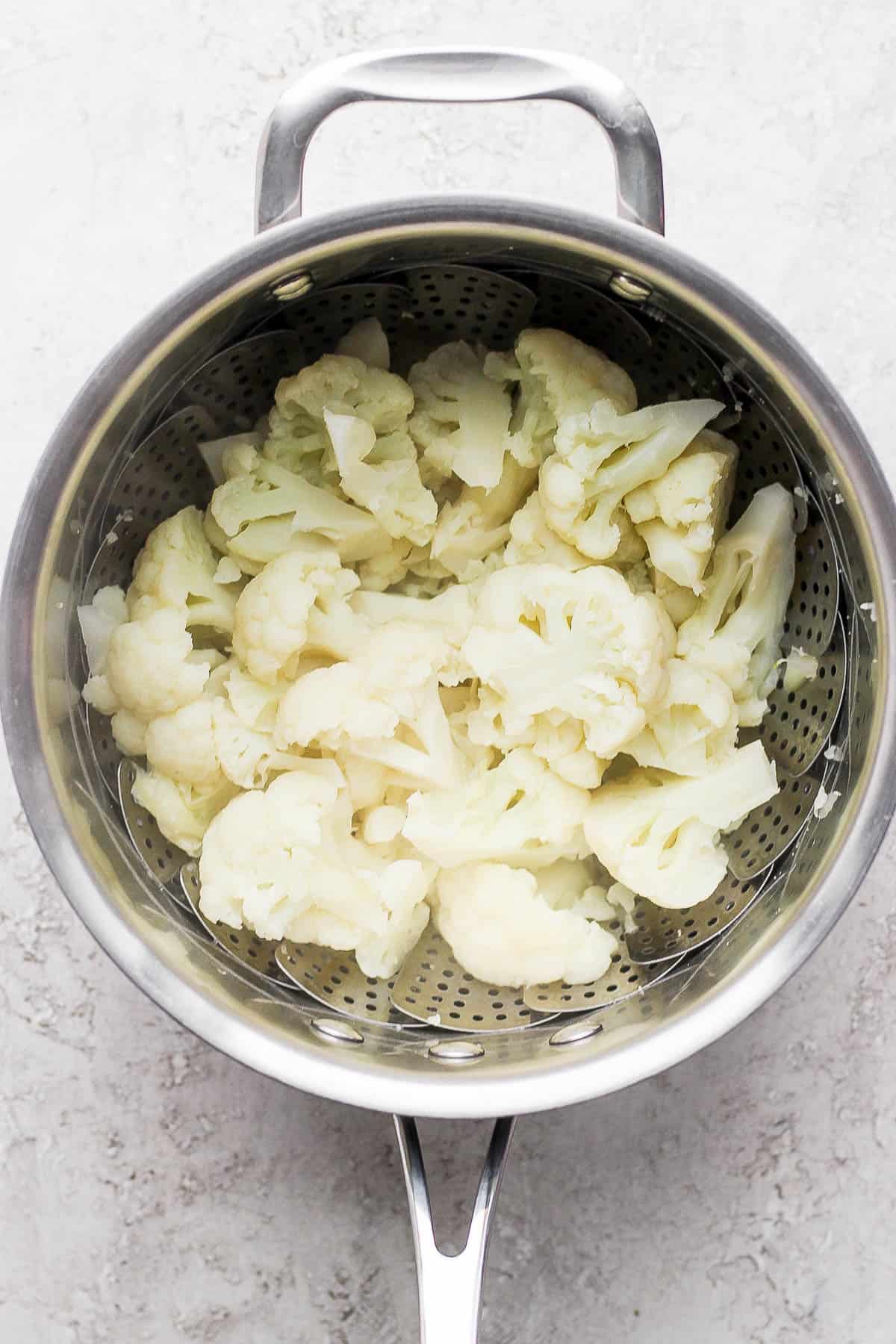 Steamed cauliflower in a steamer basket.