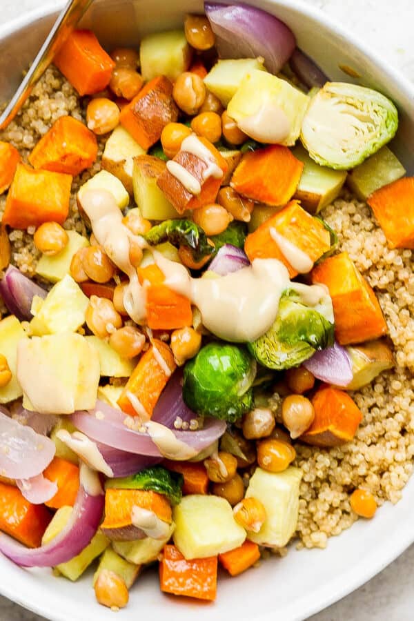 Quinoa bowl with yams, sweet potatoes, brussels sprouts and peanut dressing.