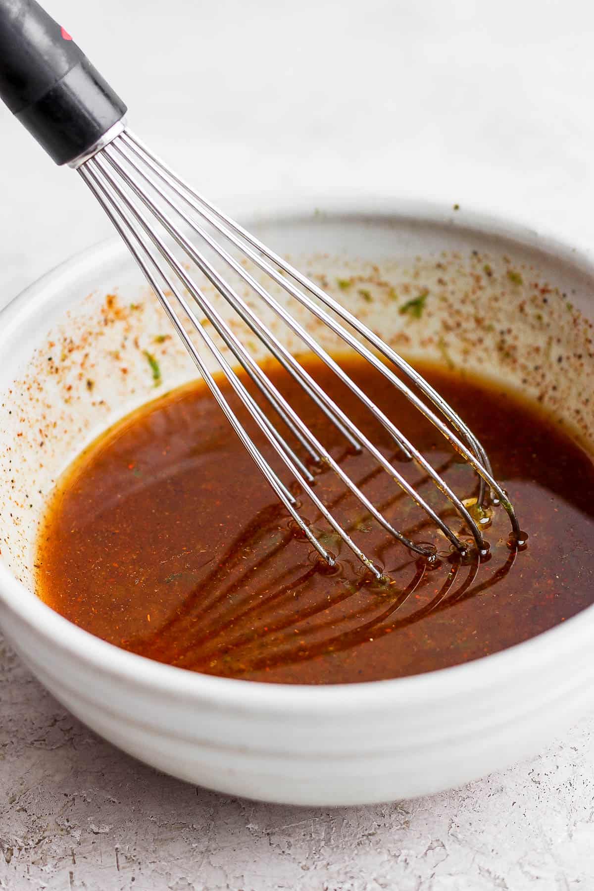 Steak fajita marinade in a bowl with a whisk.