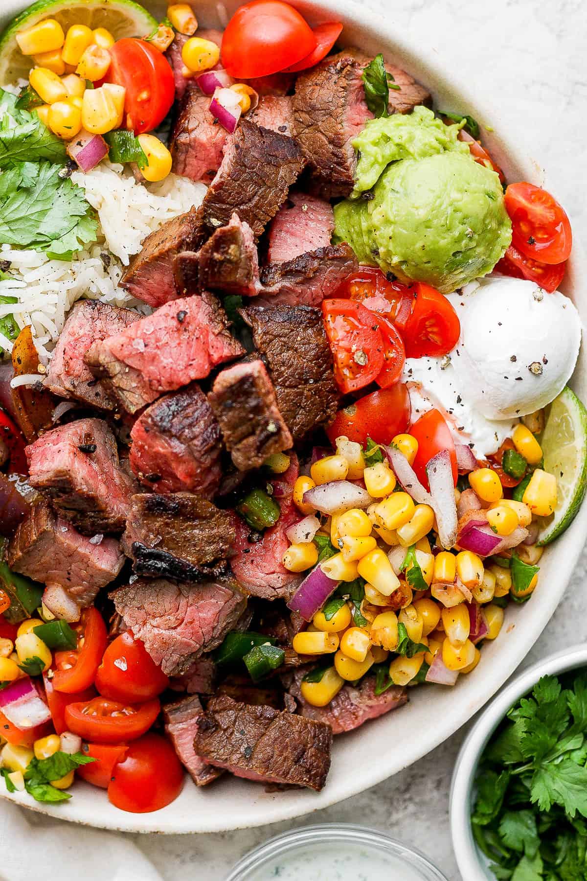 A steak fajita bowl assembled in a white bowl.