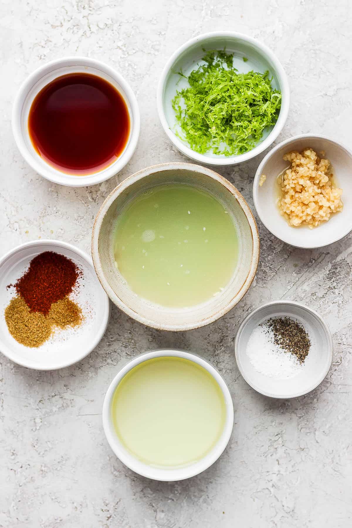 Steak fajita marinade ingredients in separate bowls.