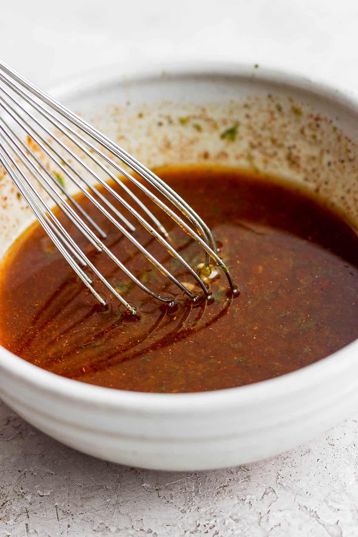 Marinade in a bowl with a whisk.
